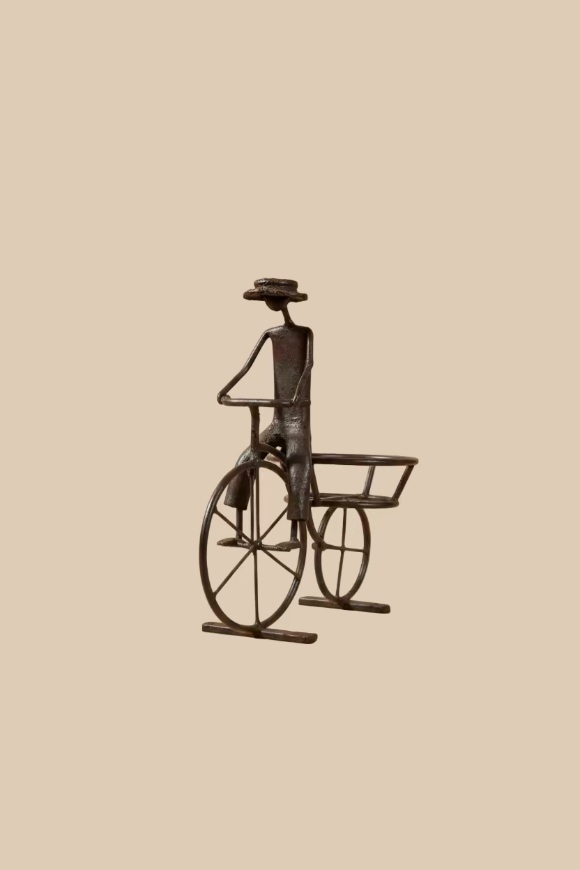 Recycled-metal Bicycle Planter with a cyclist figure showing its empty rear pot holder against beige.