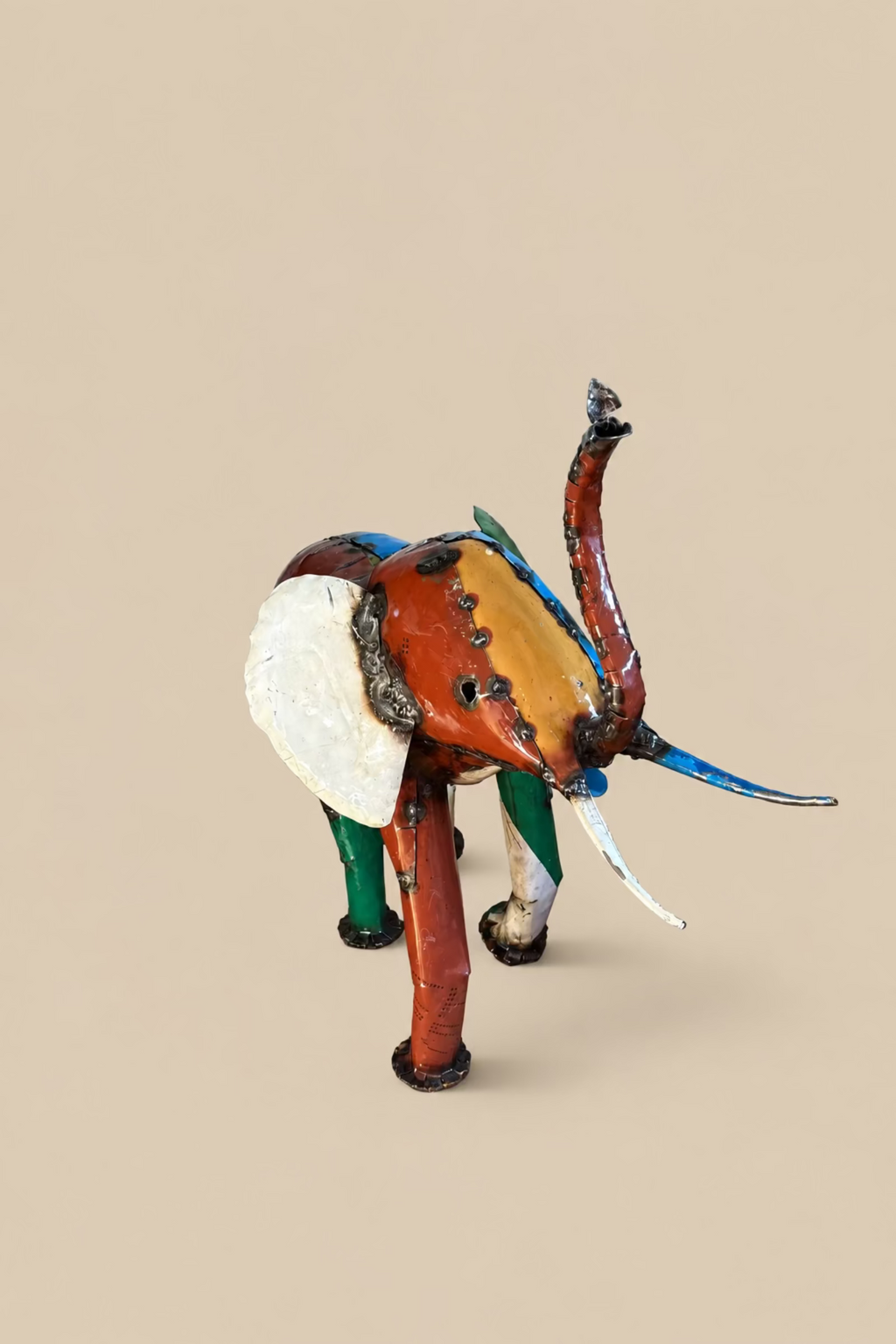 Large Elephant with orange and blue panels and a cream ear, viewed from the front at an angle.