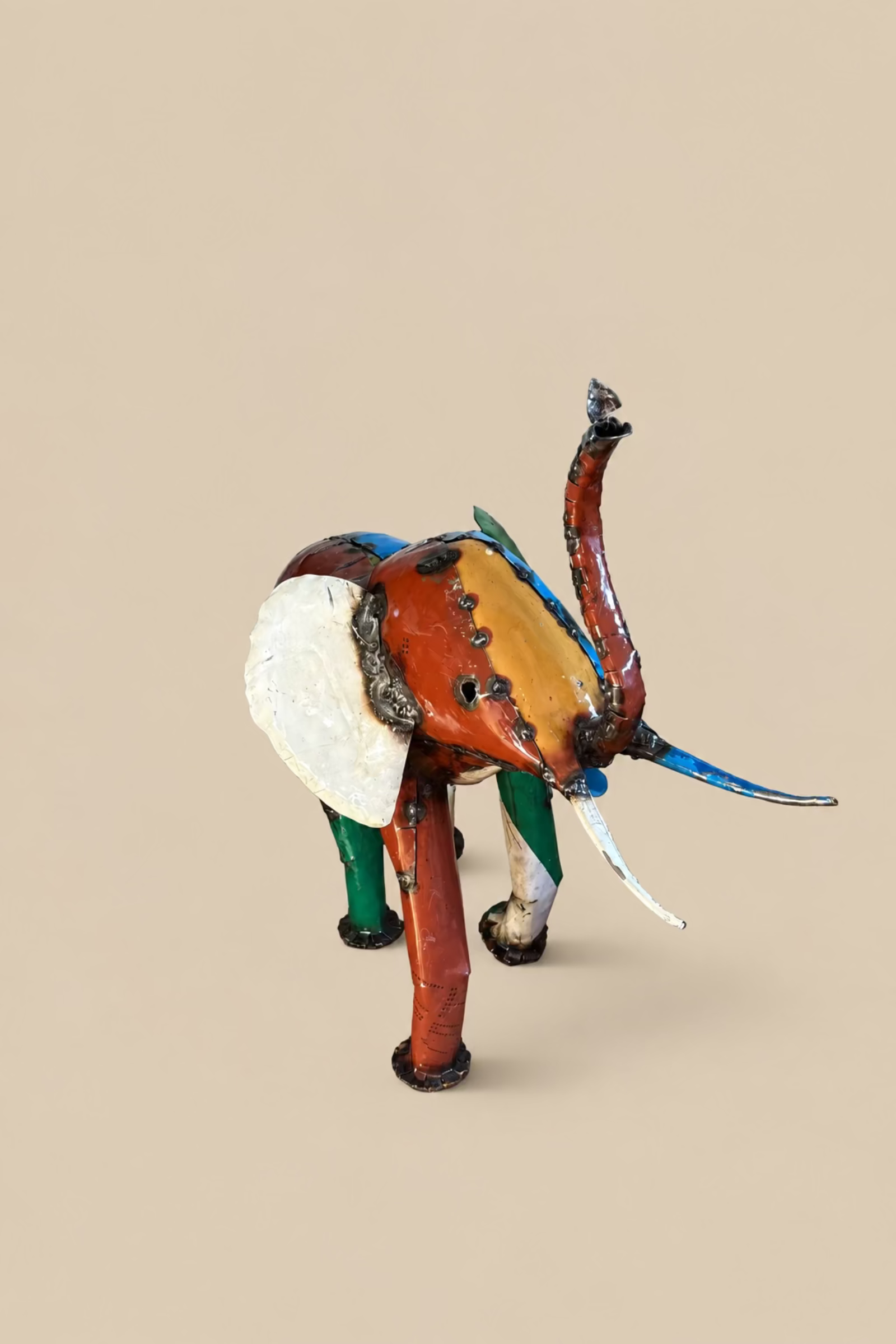 Large Elephant with orange and blue panels and a cream ear, viewed from the front at an angle.