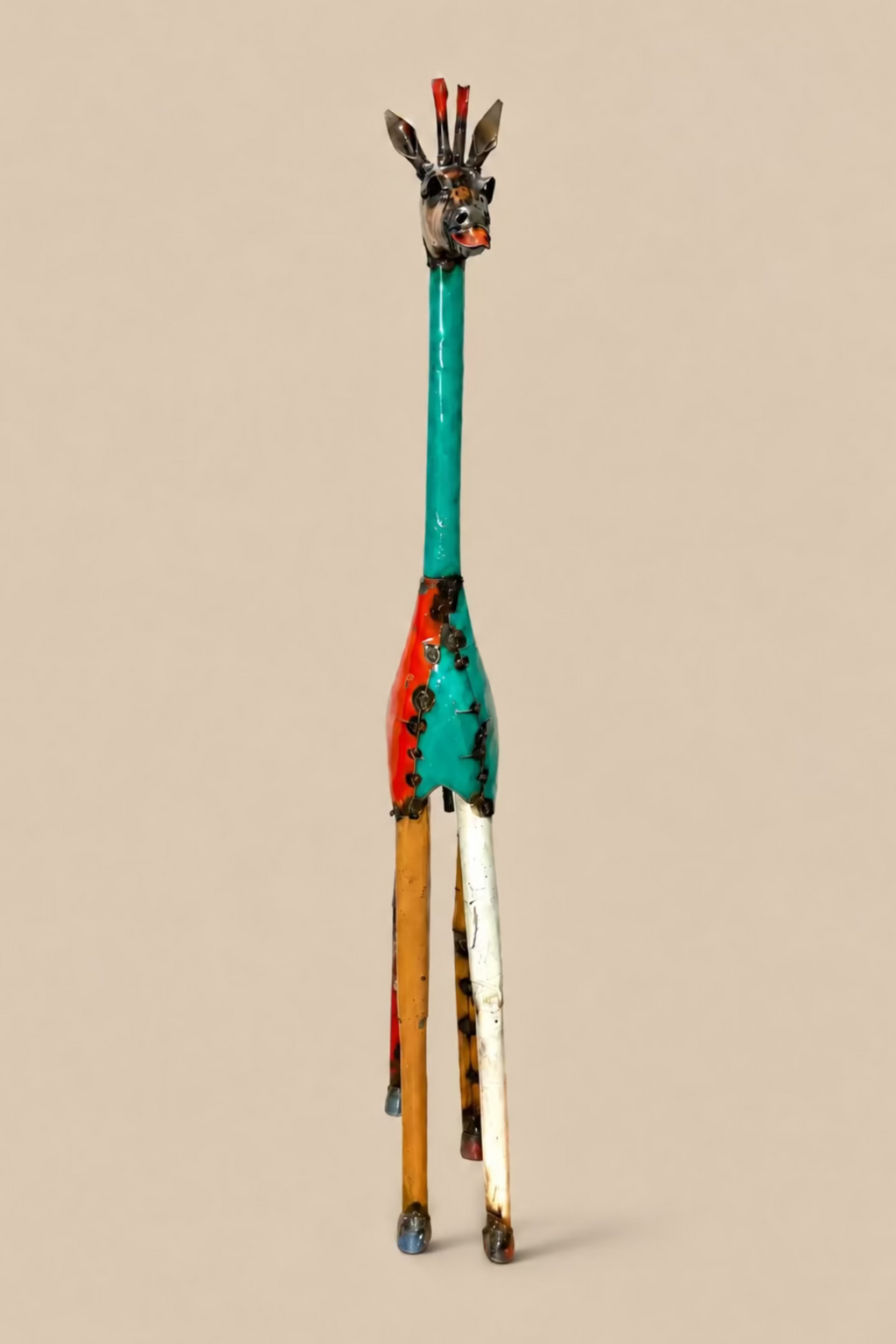 Tall Giraffe metal sculpture viewed from the front, showing its slender legs and neck.