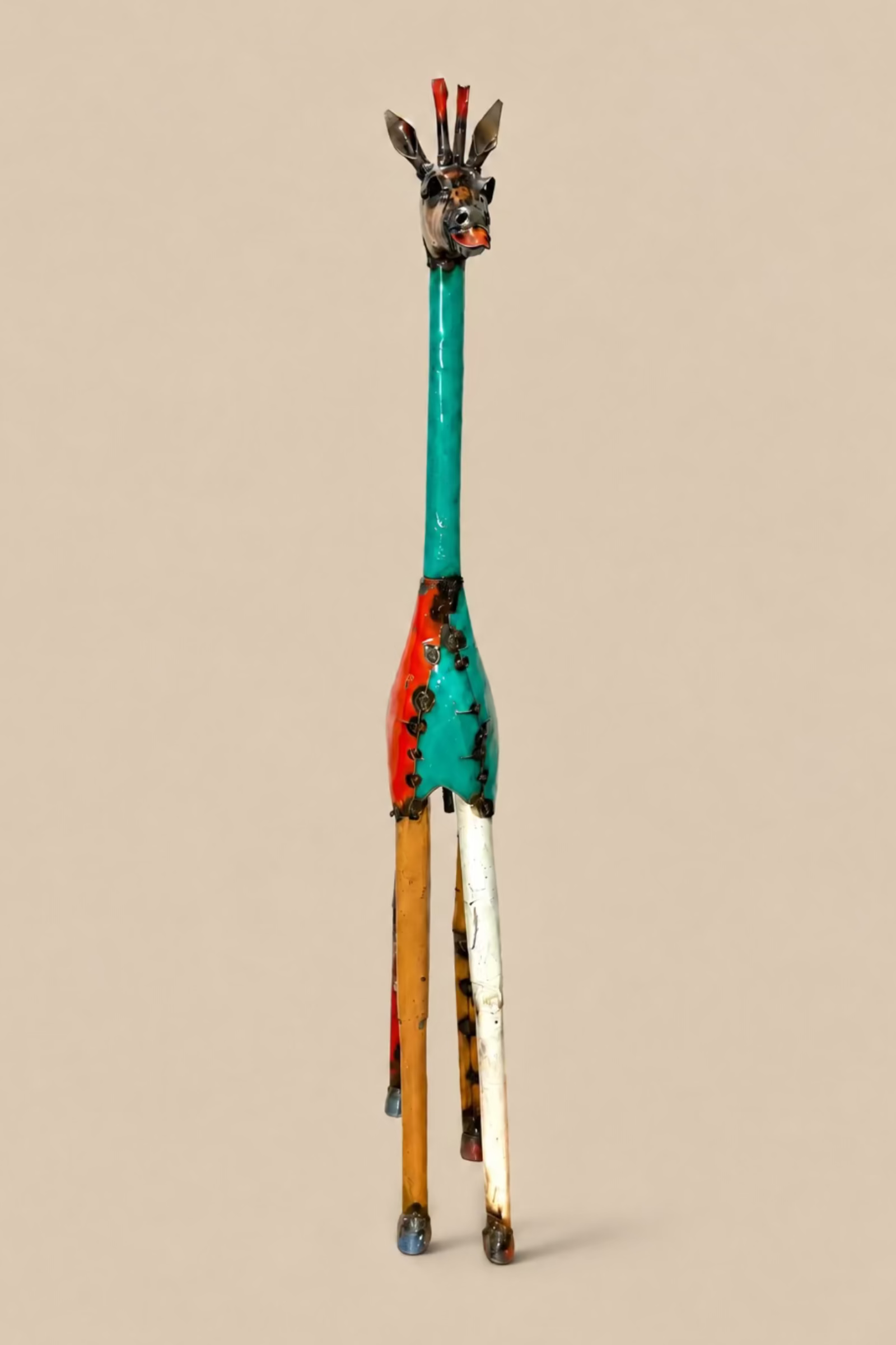Tall Giraffe metal sculpture viewed from the front, showing its slender legs and neck.