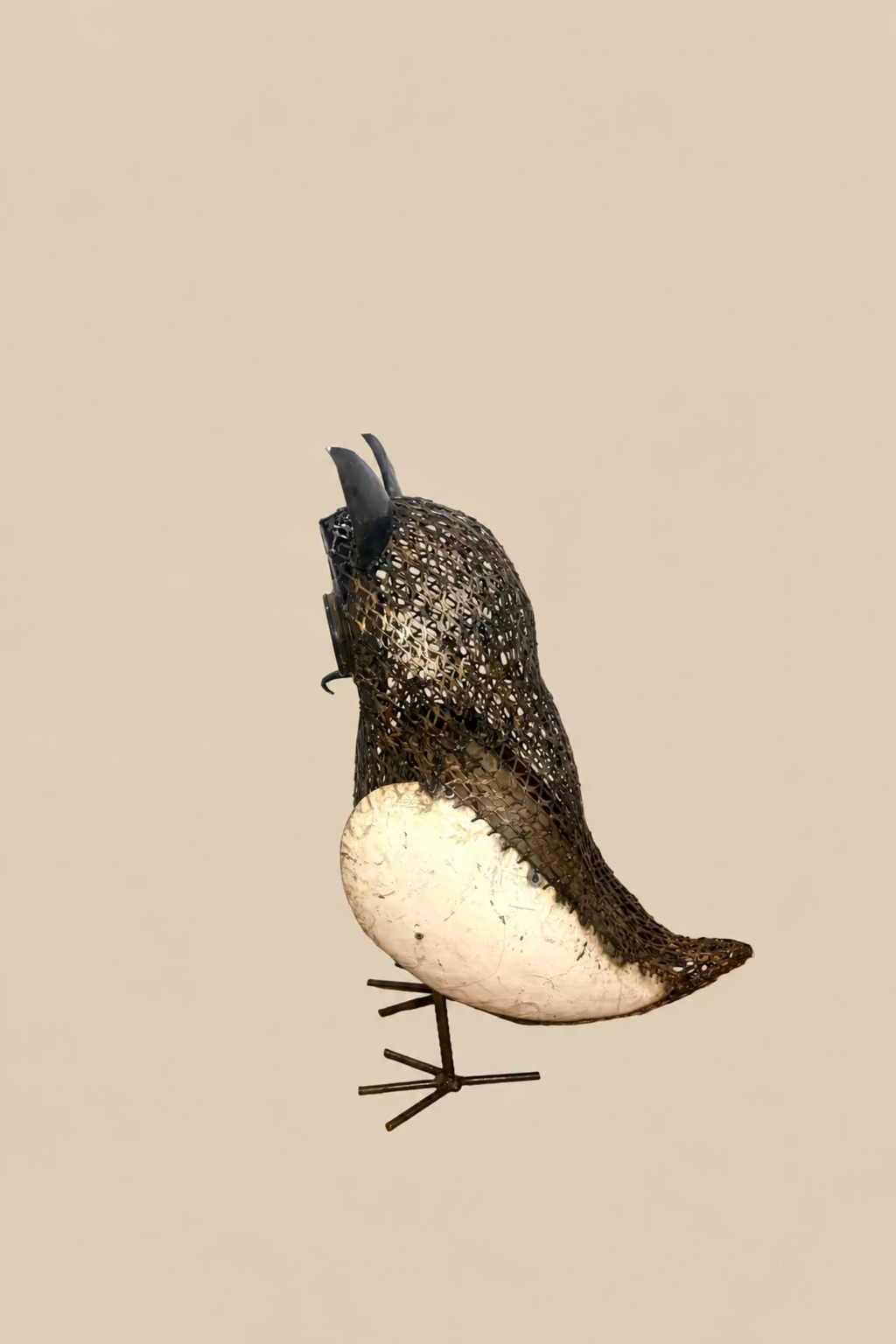 Sentinel Owl in profile, showing its cream wing and curved metal mesh back.