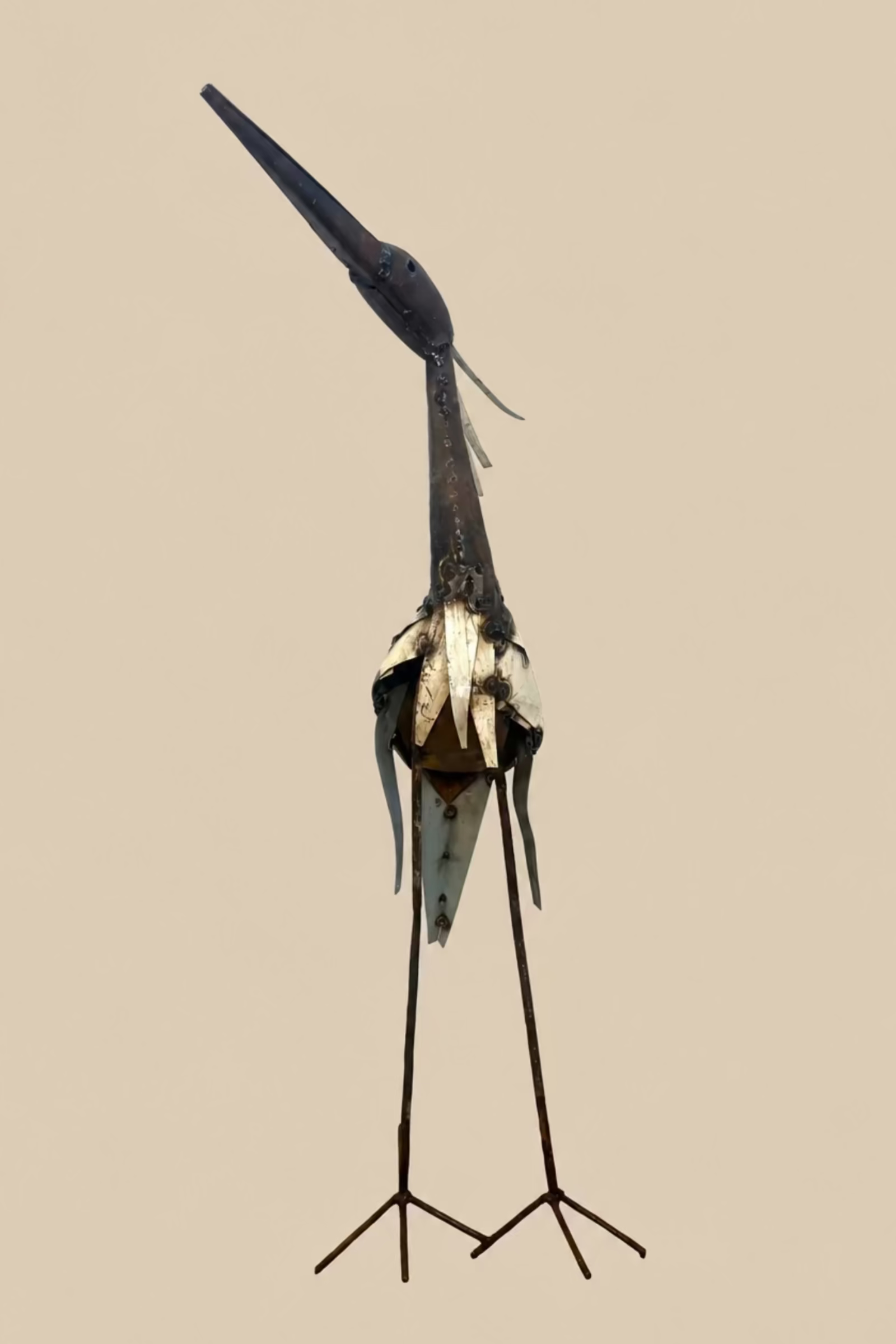 Large Heron viewed from the front, showing its narrow body, raised beak and wire feet.