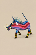 Carnival Warthog metal sculpture in blue, pink, red and lilac, with curved tusks and an upright tail.