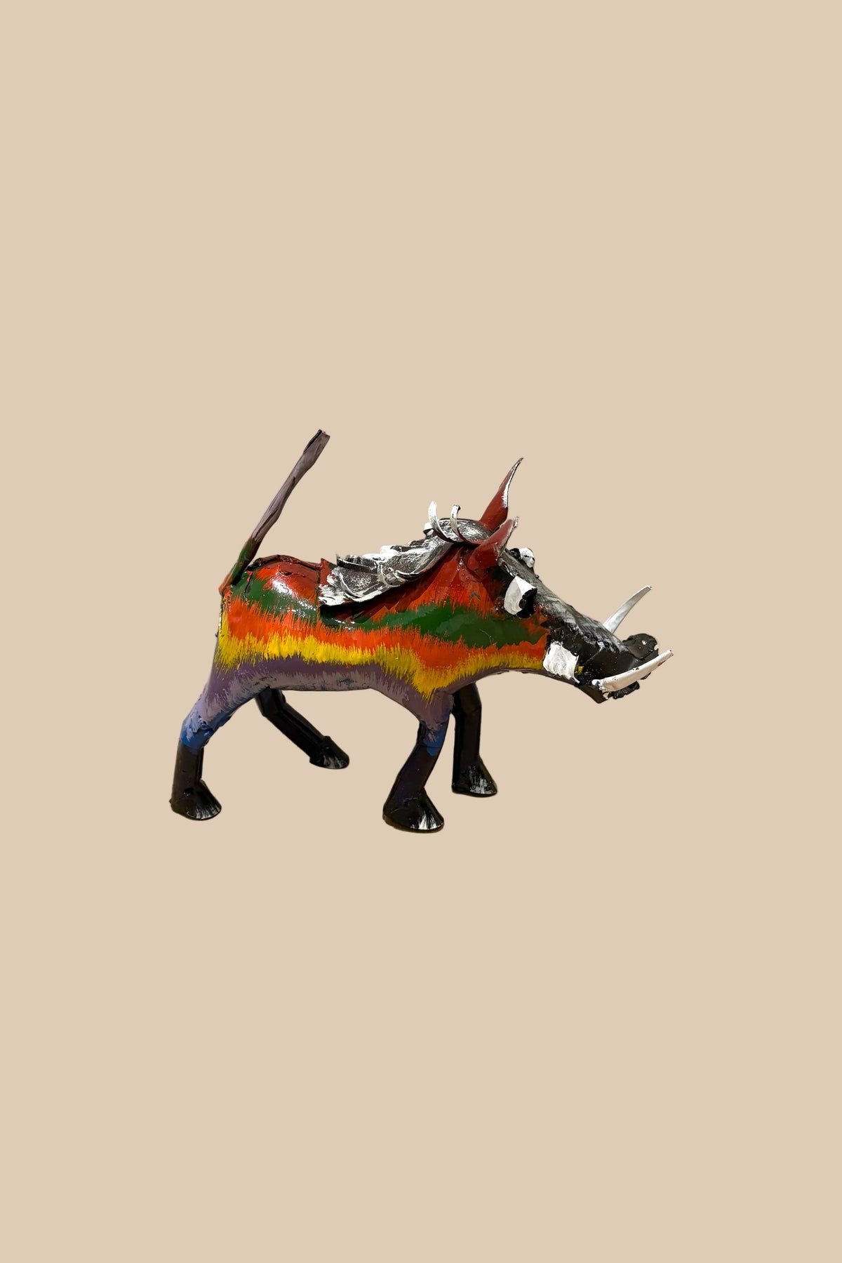 Rainbow Warthog metal sculpture with multicoloured stripes and curved tusks, viewed from the opposite side.