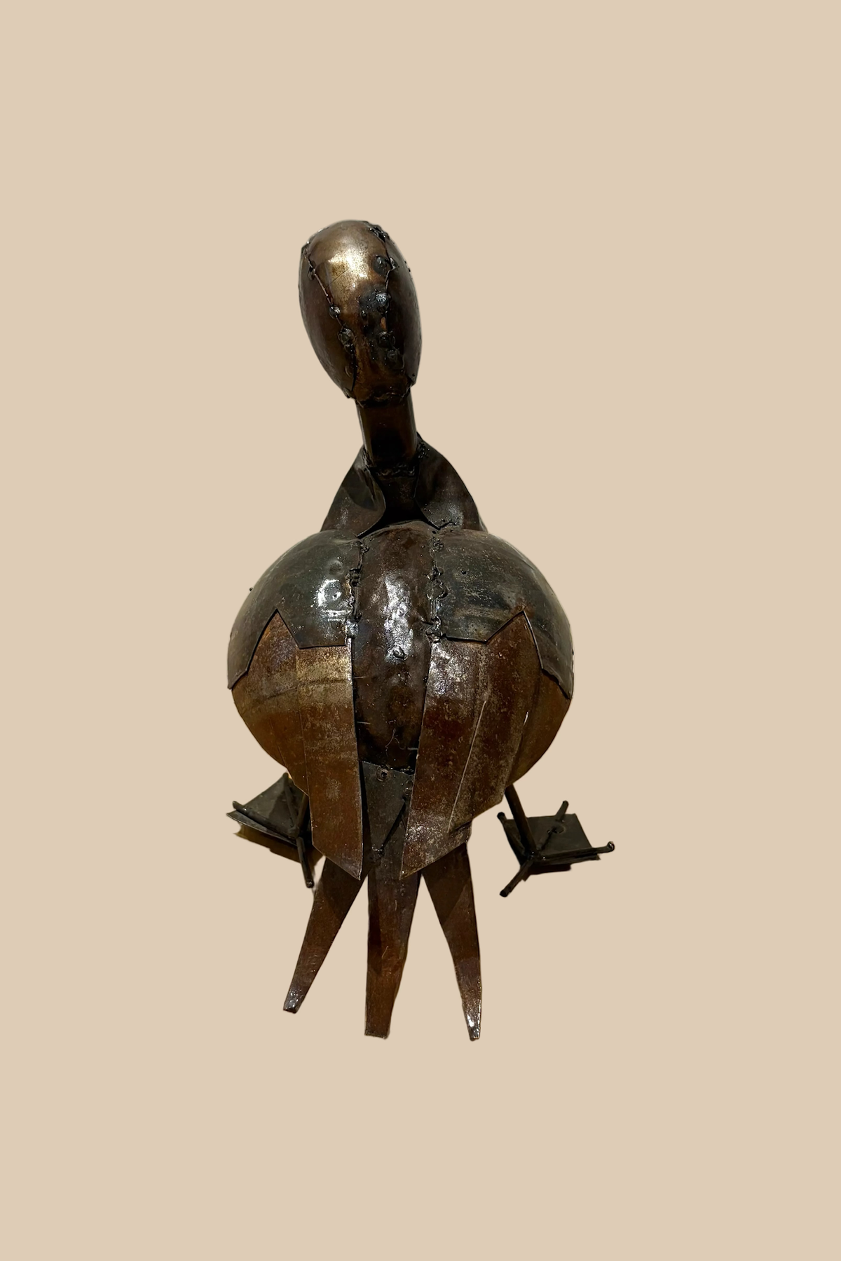 Calling Duck sculpture in dark metal with an open bill and webbed feet, viewed from the rear.