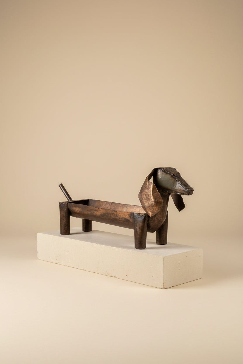 Sausage Dog Planter in recycled metal on a pale plinth