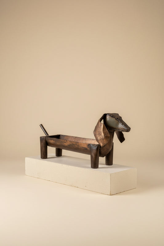 Sausage Dog Planter in recycled metal on a pale plinth