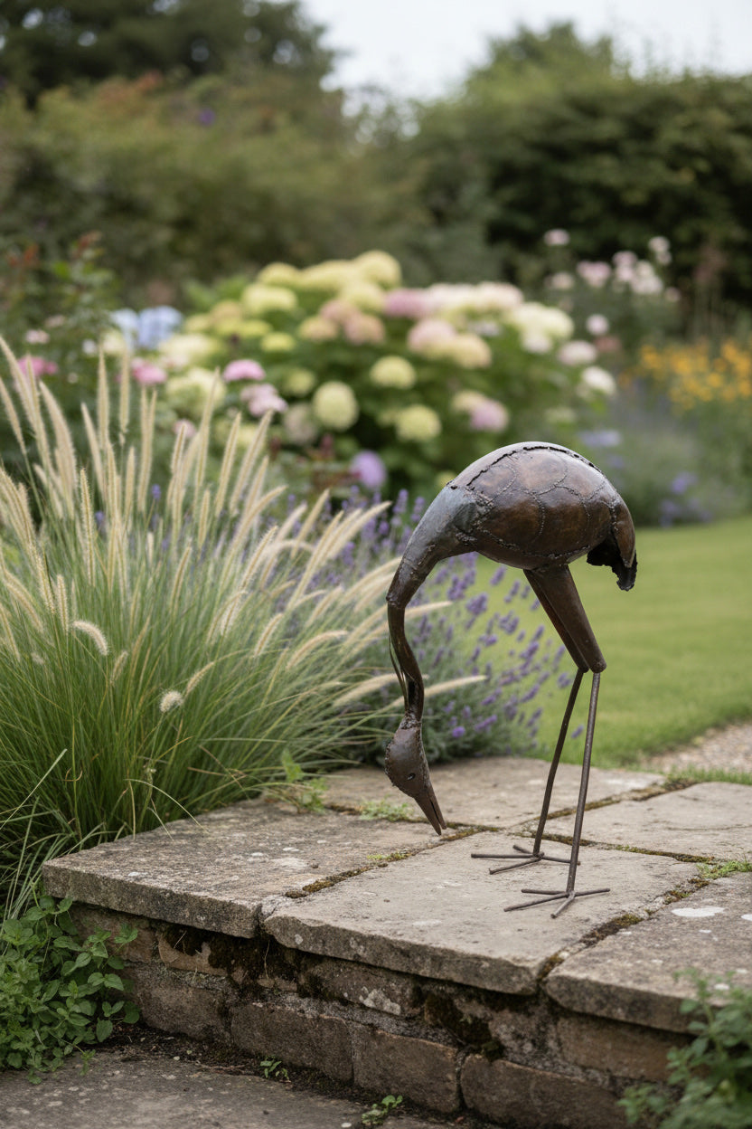 Stooping Stork recycled metal sculpture in a garden